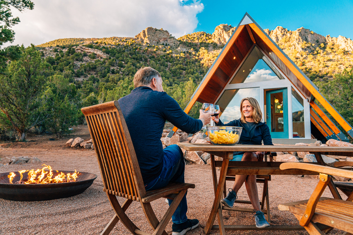 Cute Middle Aged Caucasian Couple Sharing Dinner and Wine Together in Front of a Modern Xeriscaped Tiny House in the Unaweep Canyon