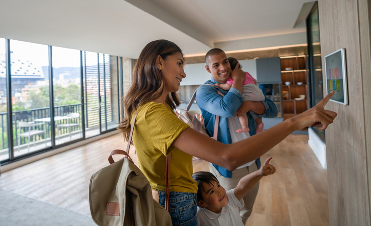 Family leaving the house locking the door using automated security system - smart home concepts.