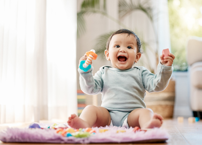 Shot of an adorable baby playing with toys at home