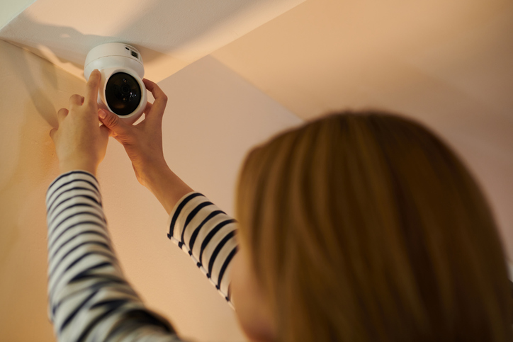 Woman Installing Security Camera