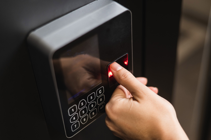 A woman opens the door with her fingerprint. Modern keyless entry lock