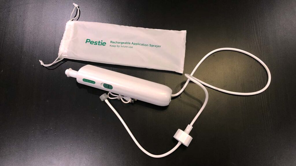 The Pestie Pest Plans wand applicator used to spray your yard. It is a white hair curler sized cylinder with a hose that connects to the baggie provided by Pestie